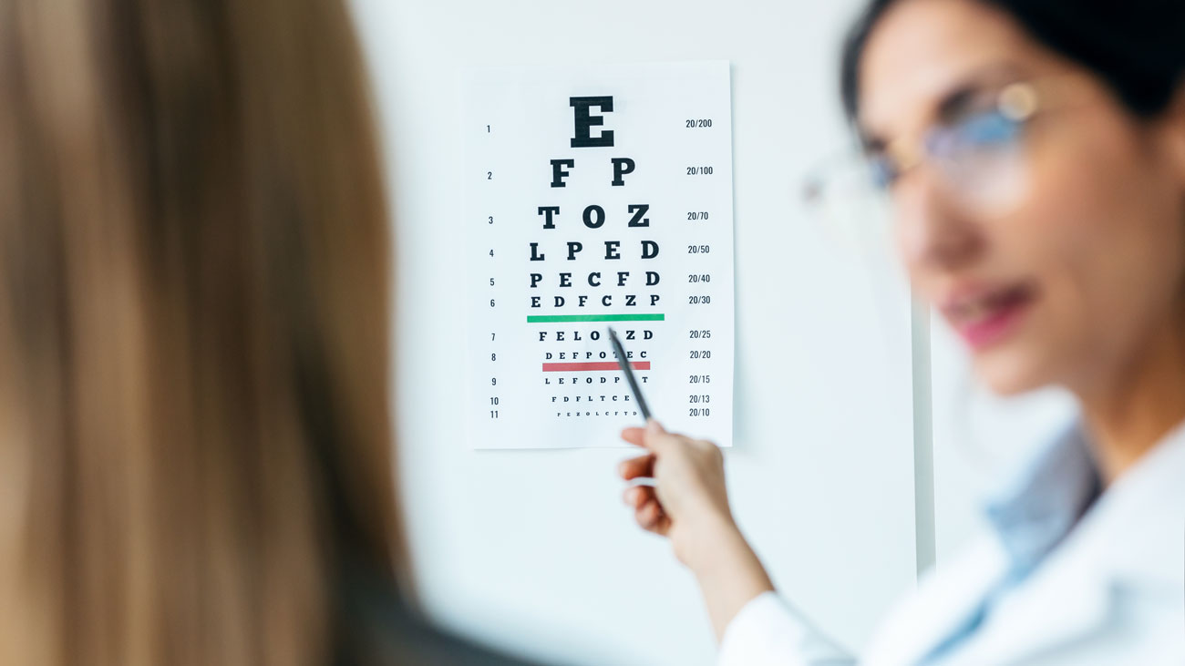 Optician doing sight test with eye chart