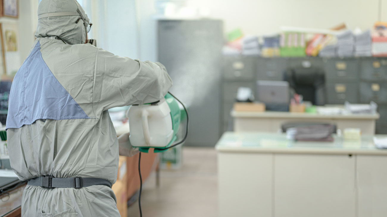 A haz-mat suited worker disinfecting premises