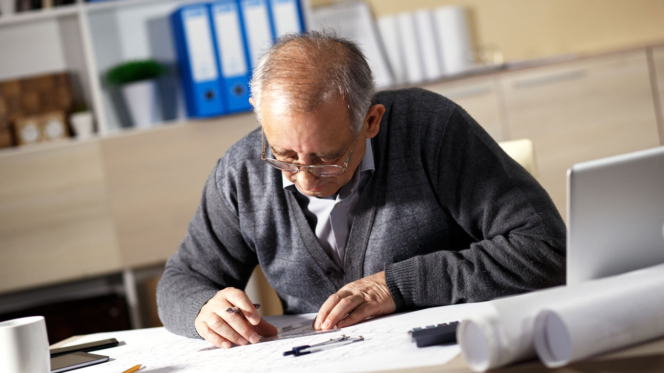 An older employee working at a desk