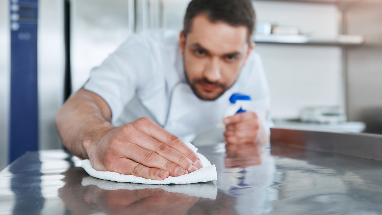 A chef wiping down a surface