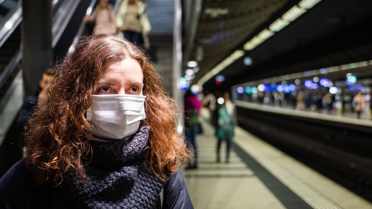 A commuter wearing a face mask in a train station