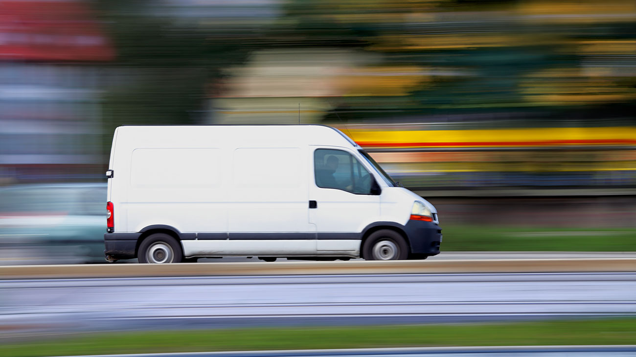 A van speeds along a road