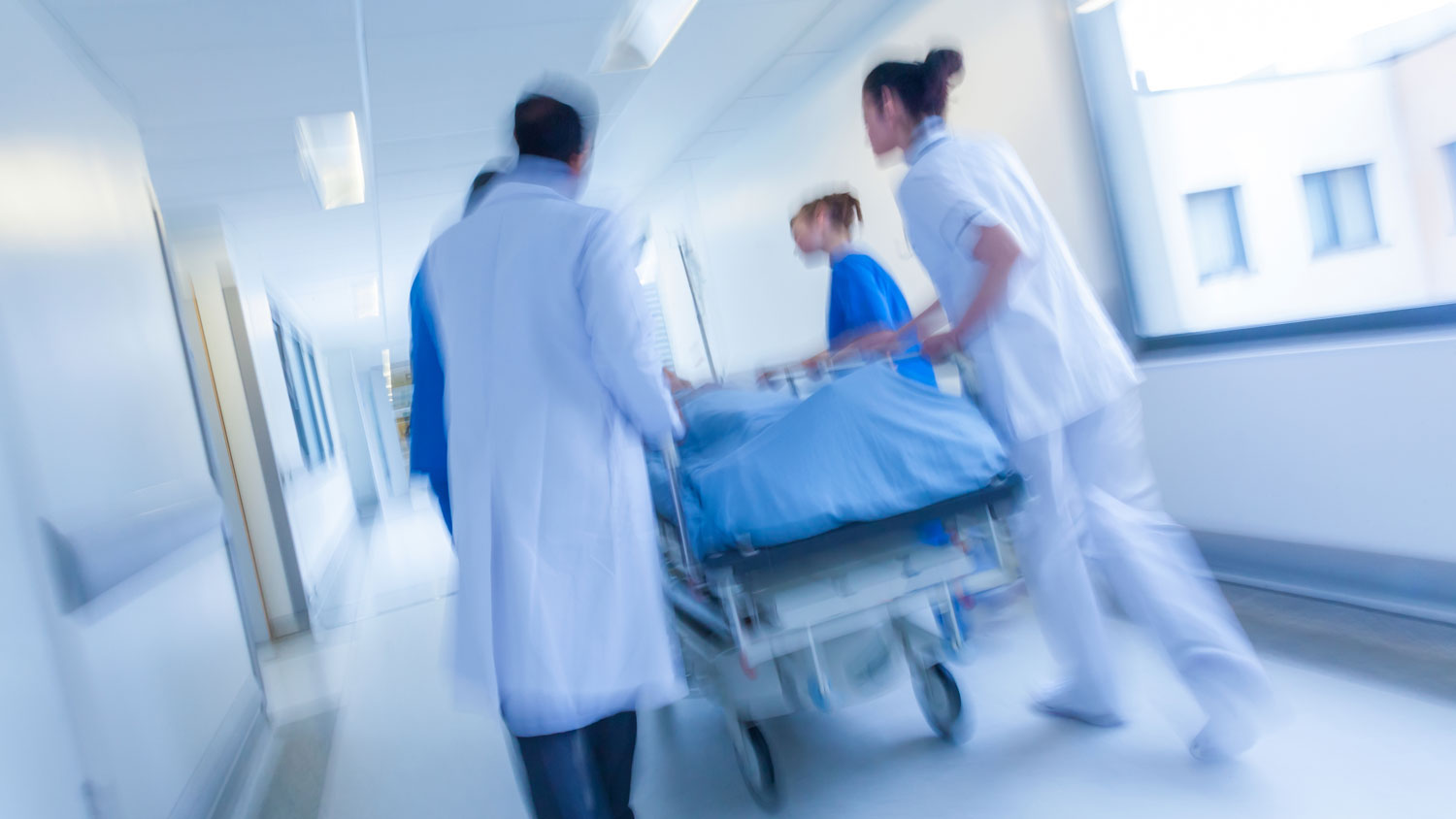 A gurney being wheeled down a hospital corridor